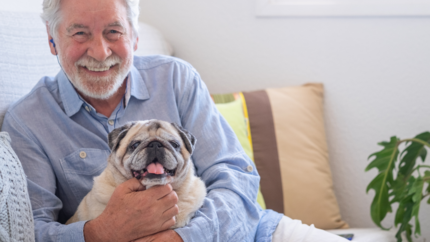 Mand smiler og krammer sin hund